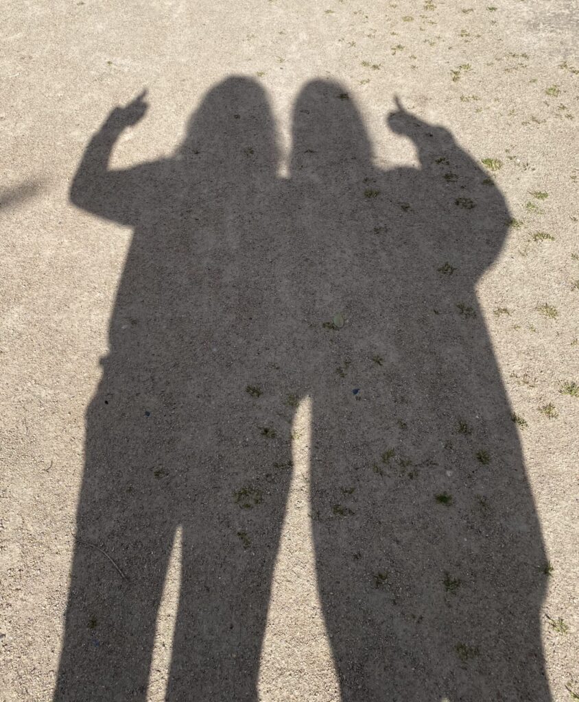 Shadow of two people, each doing a thumb's up sign.  Shows it is not just 3D shapes in this world but lighter ethereal qualities